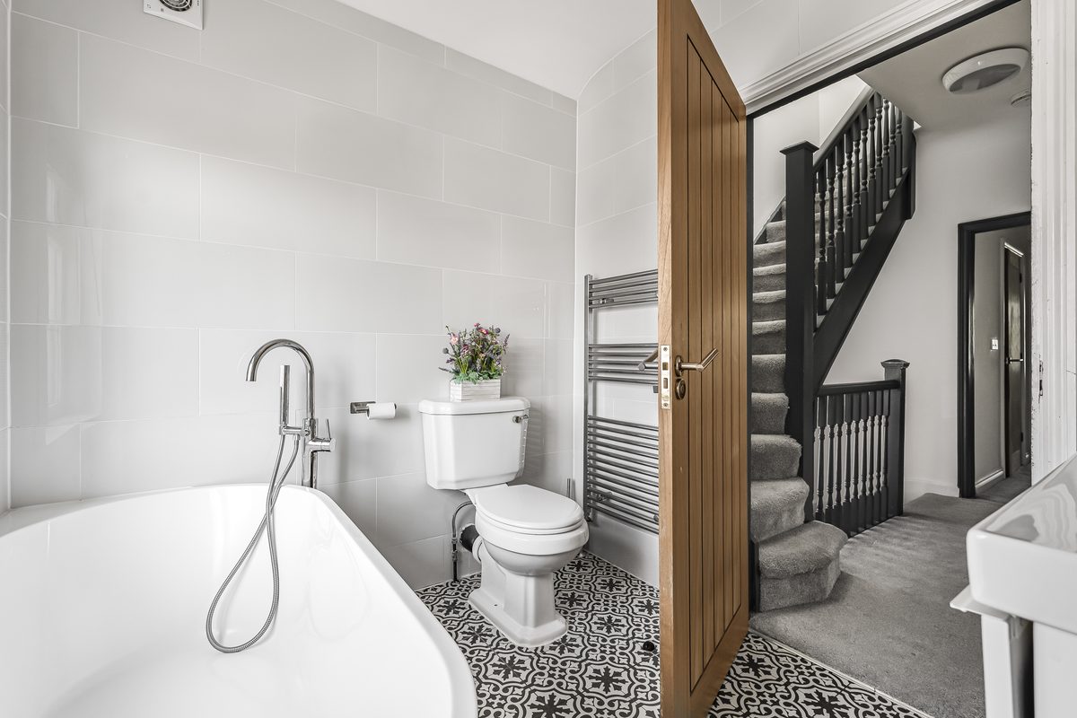Bathroom with freestanding bath and patterned tile floor