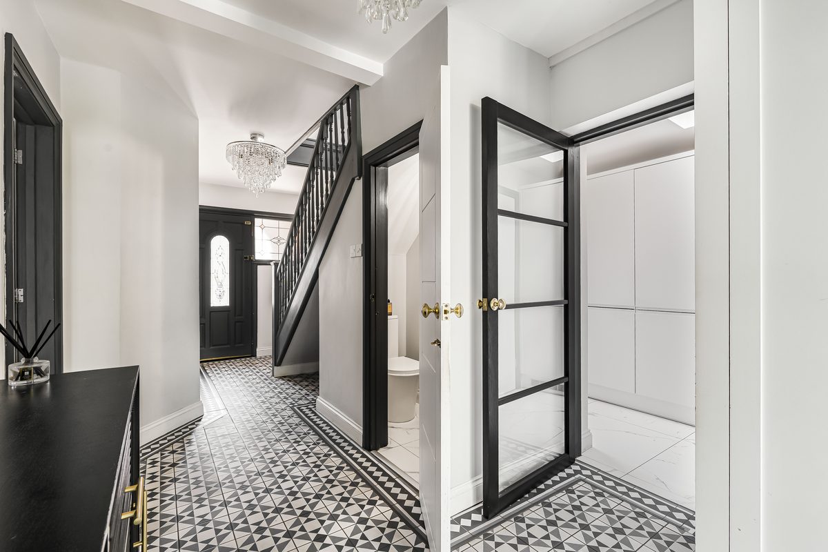 Monochrome hallway with patterned floor and crittall doors
