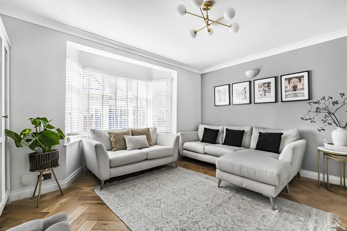 Bright living room with grey sofa and parquet flooring